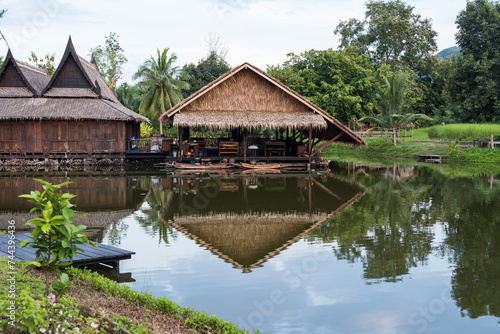 Traditional wooden thai house by canal with wood boat