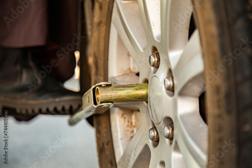 Close up of person changing a flat tyre unscrewing wheel nuts photo