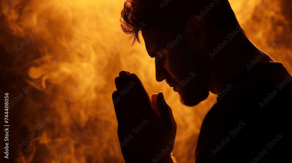 A portrait of a person praying is presented, showcasing silhouette lighting, a colorized effect, and a smokey background. A portrait of a person praying is presented, showcasing silhouette lighting, a colorized effect, and a smokey background.