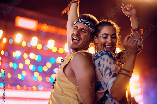 Foto Carefree couple having fun while dancing on open air music concert at night