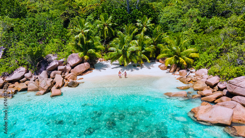 top view at a couple of men and women on vacation at Seychelles visiting the tropical beach Anse Lazio Praslin Seychelles. drone view at a tropical lagoon with turqouse colored ocean and palm trees photo