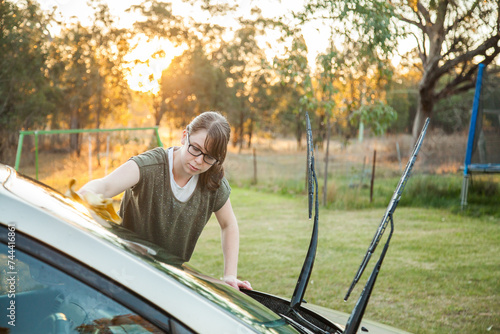 Person drying clean car with shammy photo