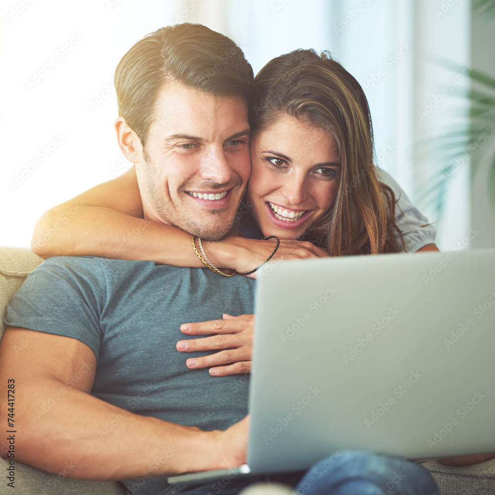 Laptop, happy and woman embracing man on sofa networking on social media, website or internet. Smile, love and female person hugging husband reading online blog with computer in living room at home. Laptop, happy and woman embracing man on sofa networking on social media, website or internet. Smile, love and female person hugging husband reading online blog with computer in living room at home.