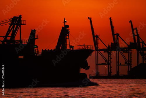 関門海峡の朝焼けの中のガントリークレーンと貨物船のシルエット20240218-2 photo