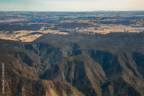 Aerial view of valley dipping down from dry farm land