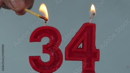 close up on a red number thirty fourth birthday candle on a white background.
 photo