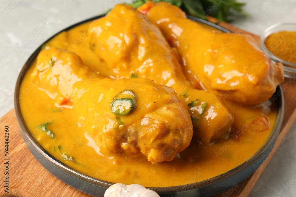 Tasty chicken curry, garlic and spice on grey textured table, closeup Tasty chicken curry, garlic and spice on grey textured table, closeup