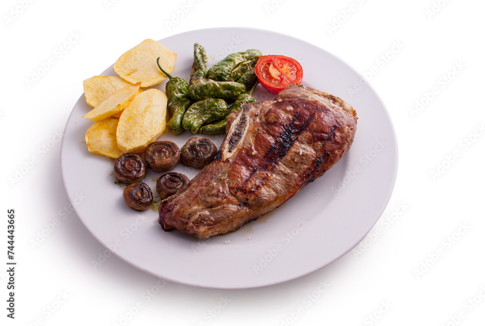 Plato de carne a la brasa, con pimientos verdes fritos, patatas fritas, champiñones y tomate Plato de carne a la brasa, con pimientos verdes fritos, patatas fritas, champiñones y tomate