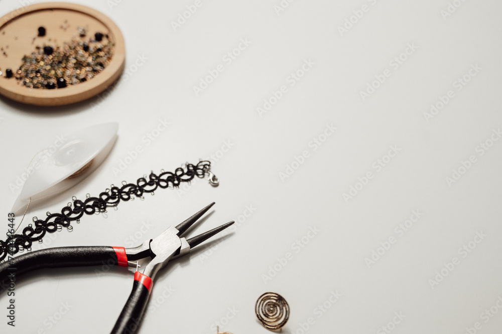 Handmade tatting jewelry flat lay. Scissors,pliers,threads and jewelry on the white background. copy space banner Handmade tatting jewelry flat lay. Scissors,pliers,threads and jewelry on the white background. copy space banner