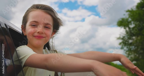Little girl looking out of car window and enjoy family travel in nature, summer vacation and road trip to the beach or mountain video photo