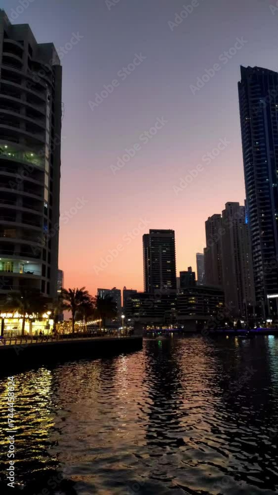 Dubai, UAE - February 17, 2024: Skyscrapers in Dubai Marina district seen from the promenade at beautiful sunset. Dynamic shot. Travel destination Dubai, UAE - February 17, 2024: Skyscrapers in Dubai Marina district seen from the promenade at beautiful sunset. Dynamic shot. Travel destination