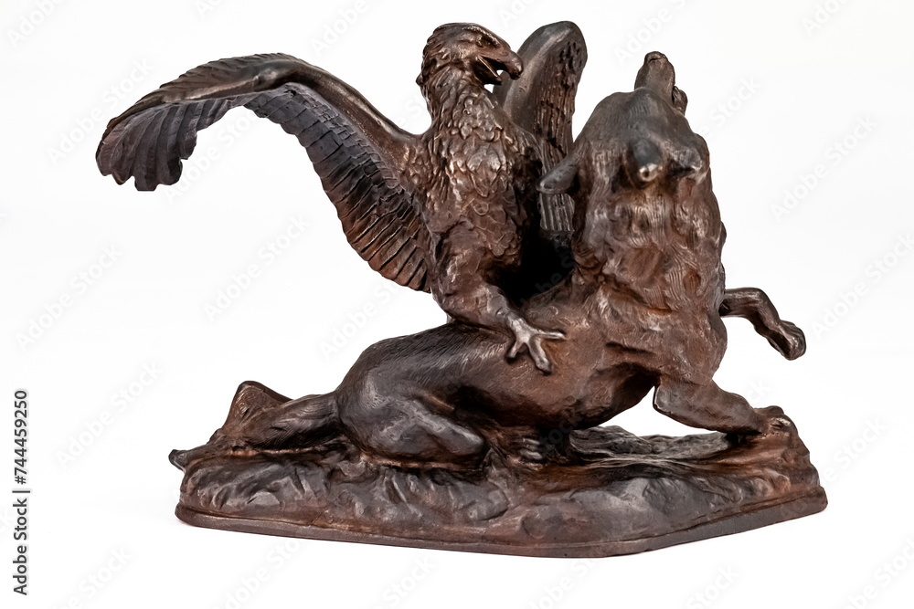 A purchased (consumer) figurine of an eagle on a wolf made of cast iron in close-up on a white background