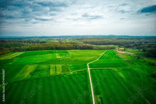 Aerial view of green fields under a cloudy sky