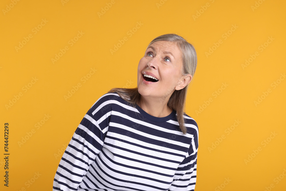 Portrait of surprised senior woman on yellow background Portrait of surprised senior woman on yellow background
