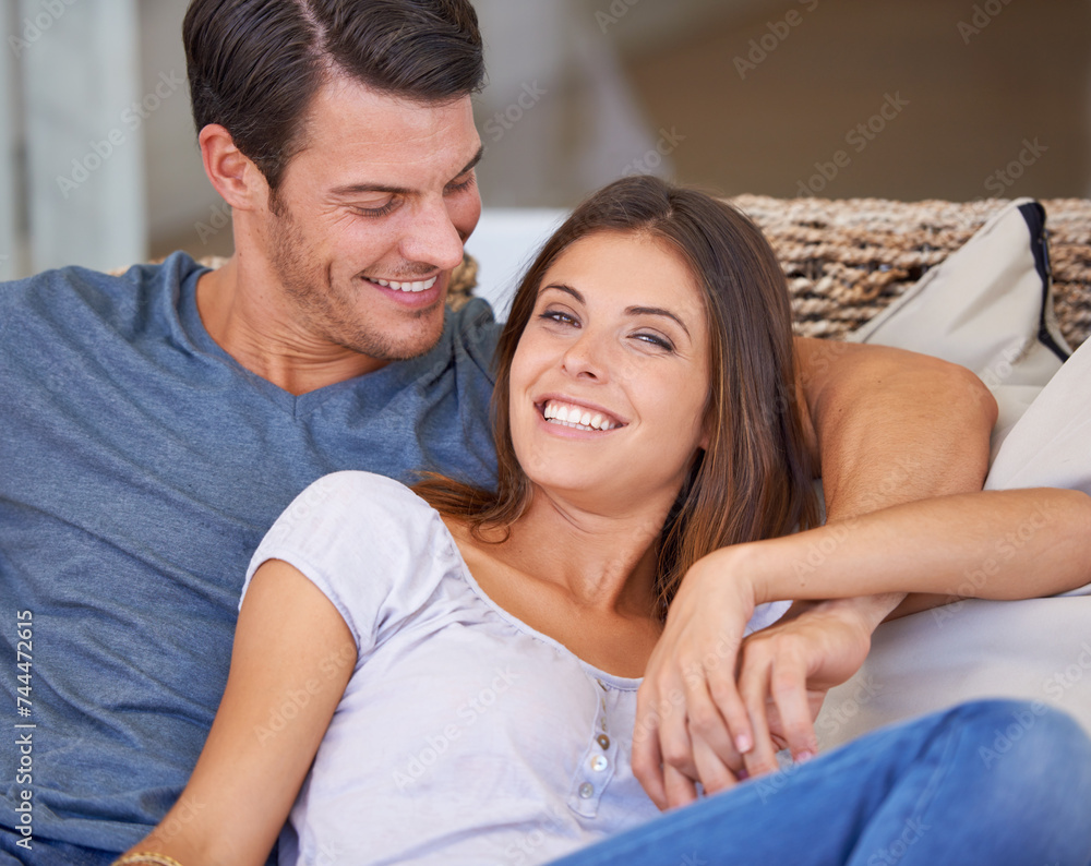 Portrait, love and couple relaxing on sofa for bonding in living room at apartment together. Happy, resting and young man and woman laying on couch for romance and marriage in lounge at modern home.