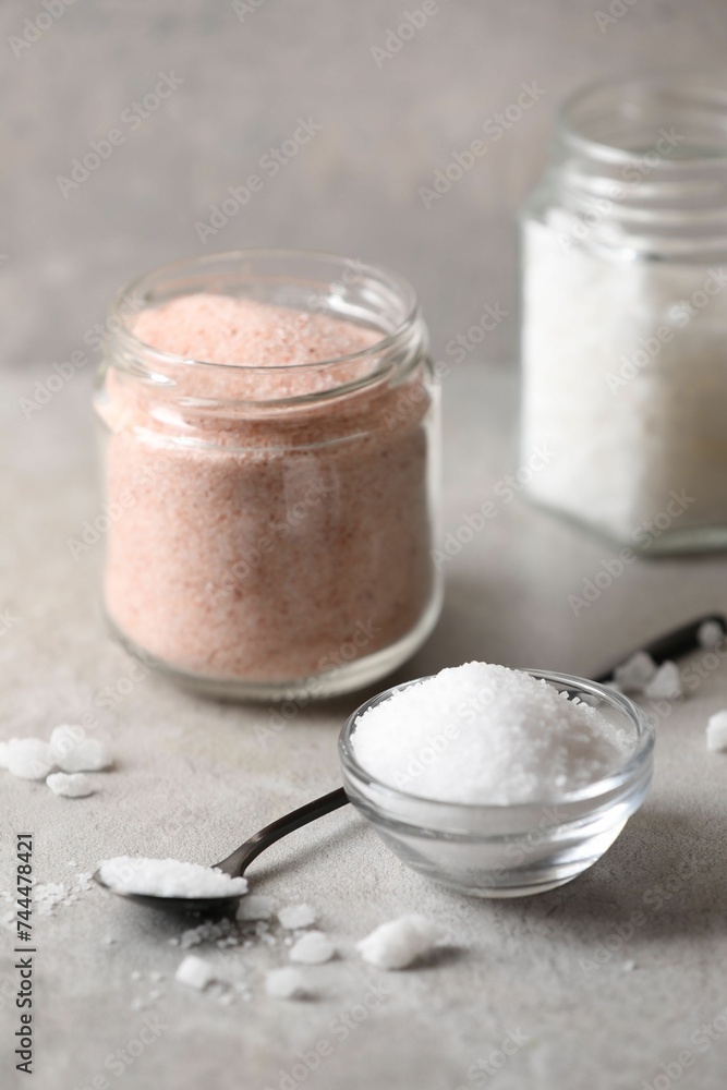 Different natural salt on grey table, closeup Different natural salt on grey table, closeup