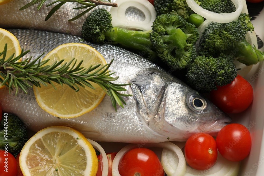Raw fish with vegetables and lemon in baking dish Raw fish with vegetables and lemon in baking dish