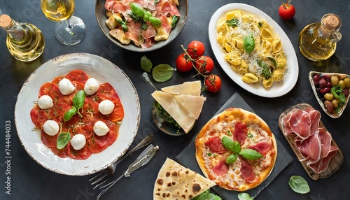 entire Italian supper table set with silverware Pizza, carpaccio, ravioli, and pasta. tomato