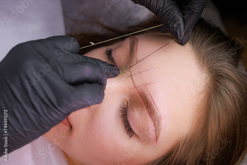 Marking eyebrows with thread before the procedure of permanent makeup. PMU Procedure, Permanent Eyebrow Makeup. photo