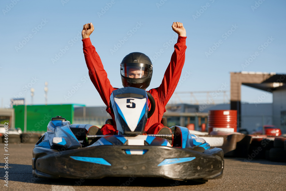 © Nomad_Soul - Happy go-cart driver raising hands up rejoicing and celebrating win © Nomad_Soul - Happy go-cart driver raising hands up rejoicing and celebrating win
