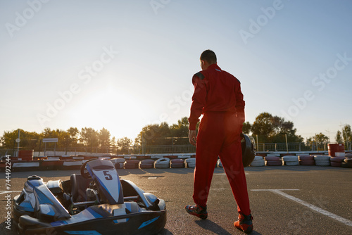 Confident go-kart driver walking to car before race at starting line