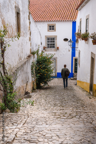 Narrow small street of the old town with stone pavement, white walls of houses. © Dainis