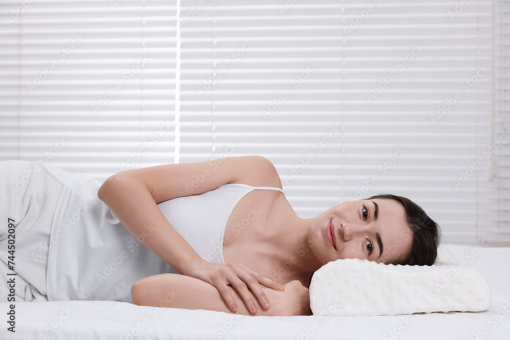 Obraz premium Woman lying on orthopedic pillow at home