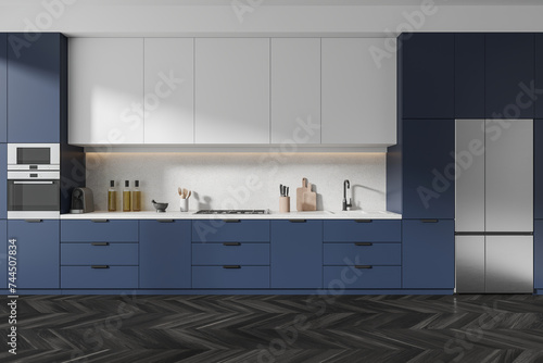 Blue modern kitchen interior with cooking cabinet and kitchenware, wooden floor