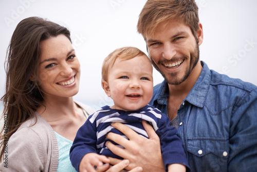 Mother, father and portrait with toddler for family, love and adoption with happiness. Man, woman and face of parents with baby for domestic, support and bonding together on white background