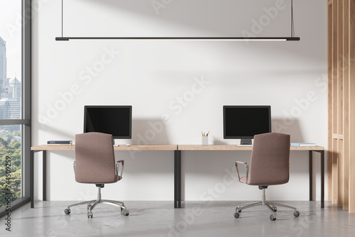 Office coworking interior with desk and pc monitors, panoramic window © ImageFlow