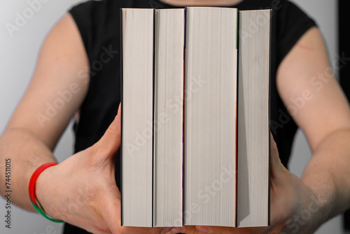 Facet trzyma w rękach cały zestaw książek do nauki  photo