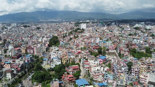 Aerial view of Kathmandu city, Nepal, showcasing the densely packed buildings and the majestic Himalayan mountains in the background.
