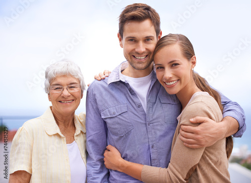 Happy, family and portrait of mother with couple, husband and wife. Embrace and smiling with love and joy for senior woman at outdoor with bonding on a peaceful day for reunion and affection