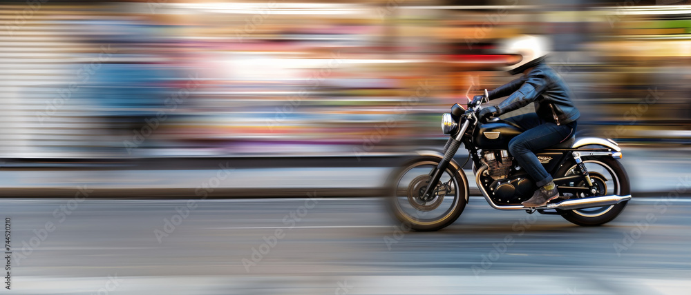 Motorcycle swiftly cuts through urban blur, a symphony of speed and motion.