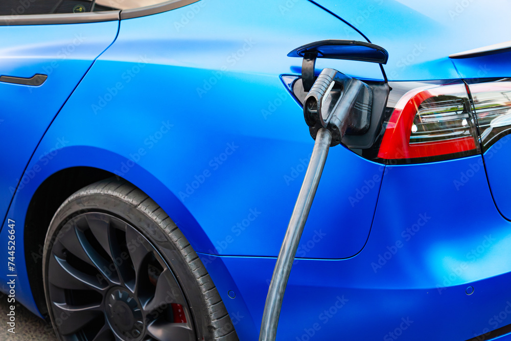 Charging an electric car with a charging cable. Charging an electric car with a charging cable.
