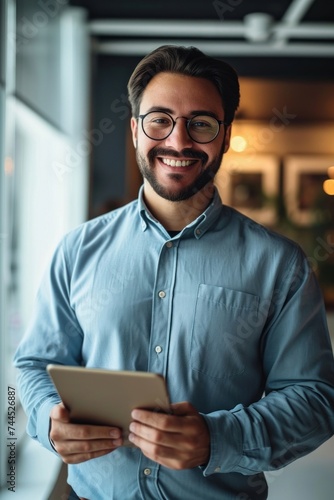 Smiling young latin business man manager using tablet computer, happy hispanic businessman employee, company worker looking at camera holding tab working standing in office. Vertical, Generative AI 