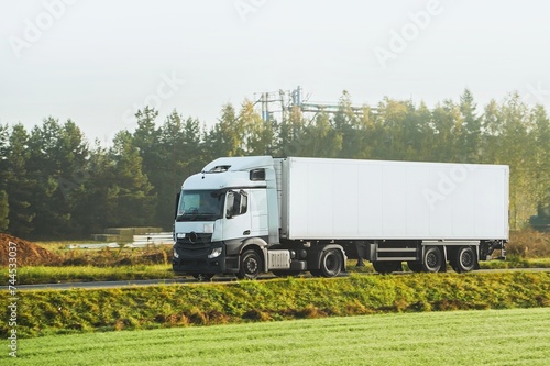 A truck transports cargo containers transported on land with semi trailers. Highway shipping and post delivery. Global commerce and industry that uses sustainable efficient logistics systems.