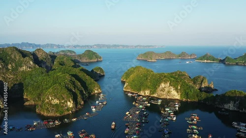 The floating villages in Ha Long Bay among karst peaks , Asia, North Vietnam, towards Hai Phong, Lanh Ha, in summer on a sunny day. photo