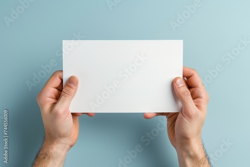 Male hands with blank sheet of paper on colorful background