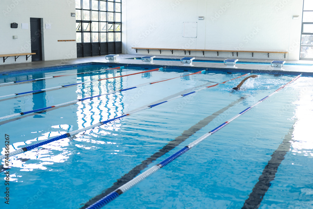 A swimmer practices in an indoor pool at a sports facility