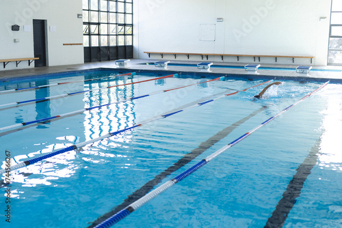 A swimmer practices in an indoor pool at a sports facility