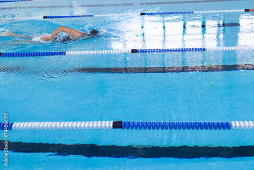 Swimmer in action at a pool competition, with copy space