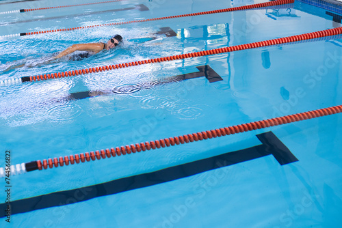 A swimmer practices in a pool, with copy space