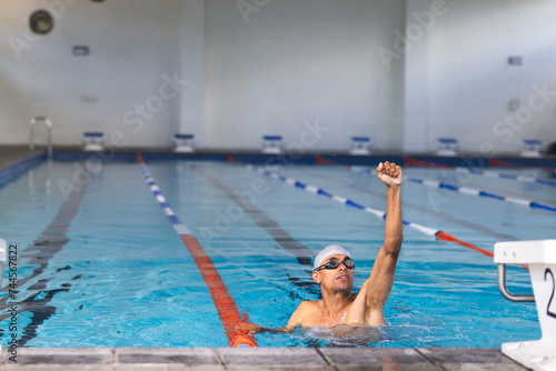 A swimmer reaches the end of the pool in an indoor facility