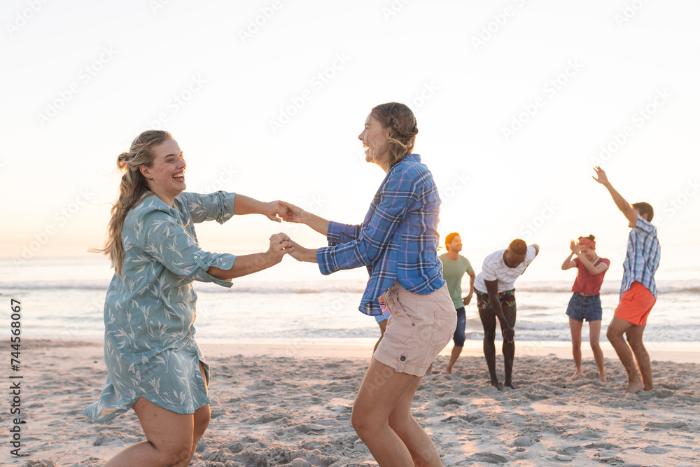 Fototapeta premium Caucasian couple enjoys a playful moment on the beach, with copy space