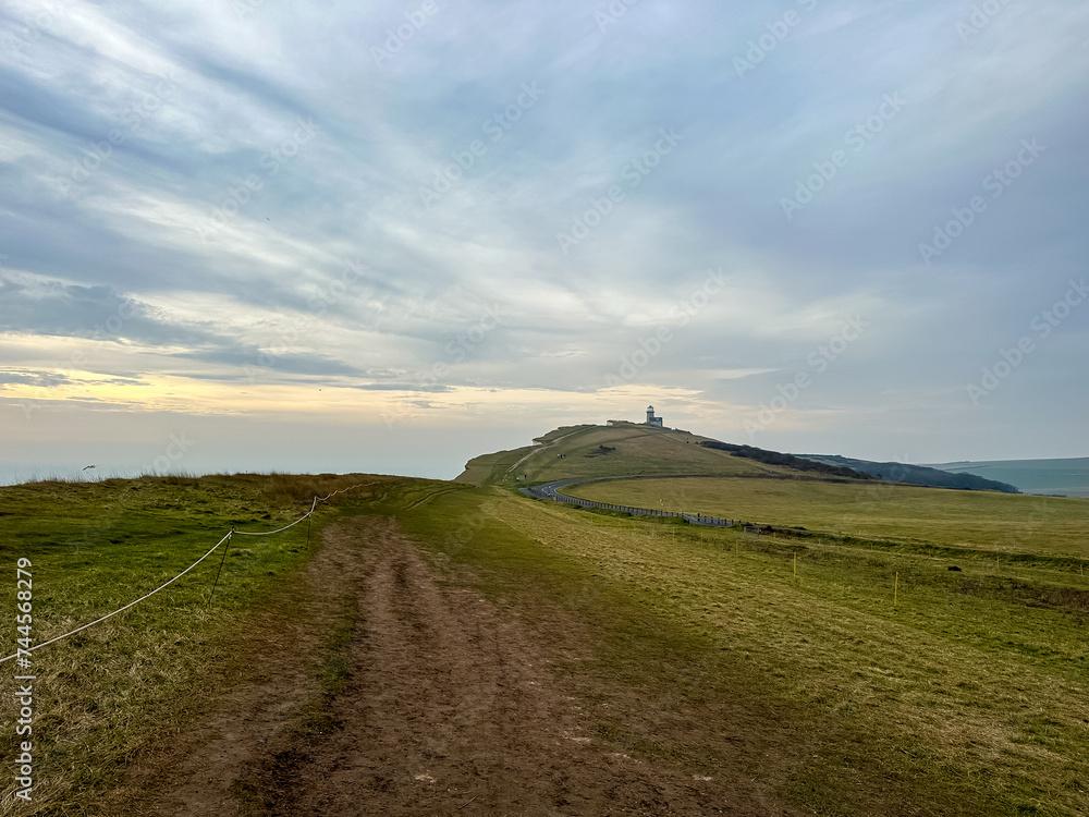 Fototapeta premium Eastbourne, England, UK. Belle Tout Lighthouse view from Seven Sisters cliffs in East Sussex. Cliff walking path view from Beachy Head to Birling Gap in Southern England.