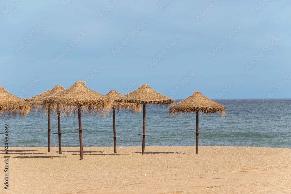 natural grass umbrella on empty beach with blue ocean