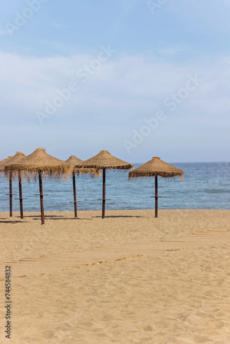 natural grass umbrella on empty beach with blue ocean © cceliaphoto