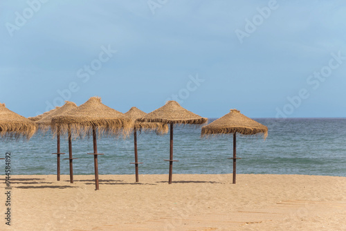 natural grass umbrella on empty beach with blue ocean © cceliaphoto