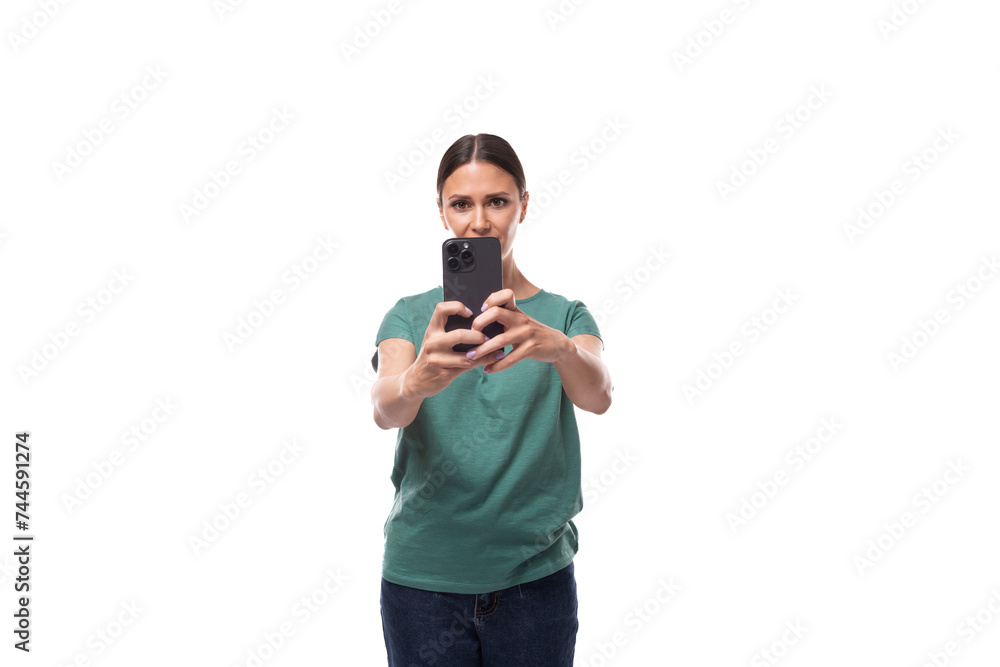 young brunette woman in love with collected hair dressed in a basic t-shirt takes a photo on the phone young brunette woman in love with collected hair dressed in a basic t-shirt takes a photo on the phone